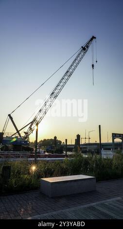 NORWALK, Connecticut, USA- 14 SETTEMBRE 2024: Una gru da costruzione si erge in mezzo a un cantiere sul fiume Norwalk costruzione di un nuovo ponte al sole del mattino Foto Stock