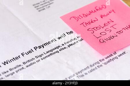 Un concetto di riduzione del pagamento del carburante invernale con una lettera e delle parole scritte su un post-it. Foto Stock