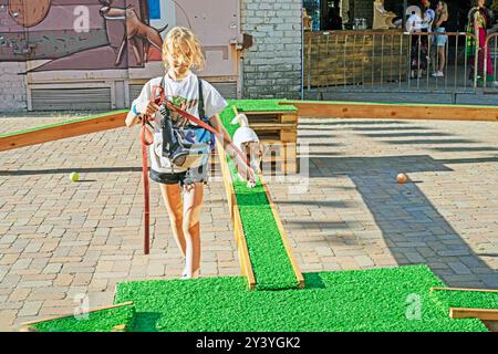 Happy girl allena un cucciolo adulto Jack Russell Terrier in un campo di allenamento in una giornata di sole. Agilità Foto Stock