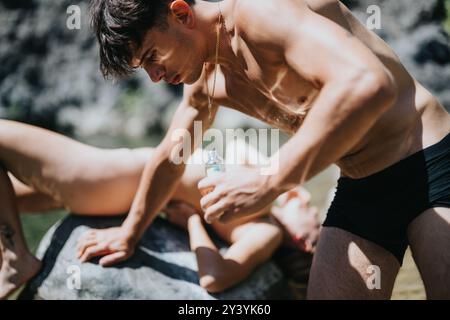Giovane coppia che si gode una giornata estiva al fiume, applicando la crema solare l'uno all'altro Foto Stock