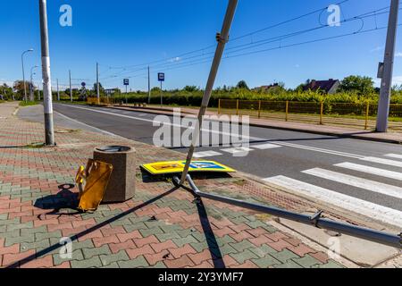 Incidente stradale sulle corsie accanto a un passaggio pedonale marcato per la scuola, segnale stradale danneggiato, figura riflettente che segnala l'attraversamento pedonale Foto Stock