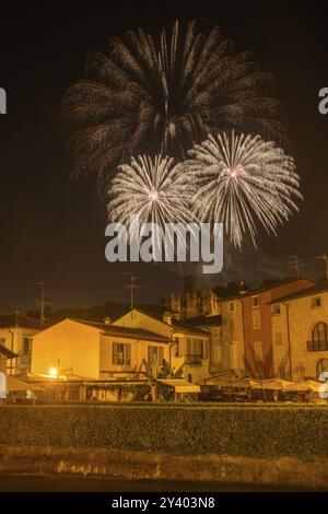 Fuochi d'artificio dal castello scaligero nelle case in primo piano di Borghetto, Valeggio sul Mincio, provincia di Verona, Italia, Europa Foto Stock