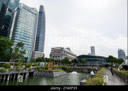 Grattacieli che torreggiano l'edificio coloniale dell'ex ufficio postale generale di Singapore, ora l'iconico Fullerton Hotel a 5 stelle a Singapore. Foto Stock