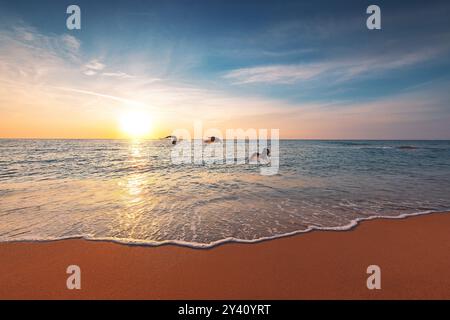 Splendida alba sull'orizzonte del mare e gabbiano che vola sopra le onde e la spiaggia Foto Stock
