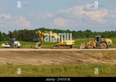 Gliwice, Polonia - 15 giugno 2023: Macchine pesanti sono attivamente impegnate nella costruzione, con escavatori che spostano terra e caricatori che trasportano materiali, Foto Stock