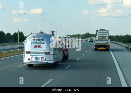 Gliwice, Polonia - 15 giugno 2023: Sotto la luce del giorno, un rimorchio di cibo scintillante si avventura lungo l'autostrada, attirando i viaggiatori con l'aroma di f Foto Stock