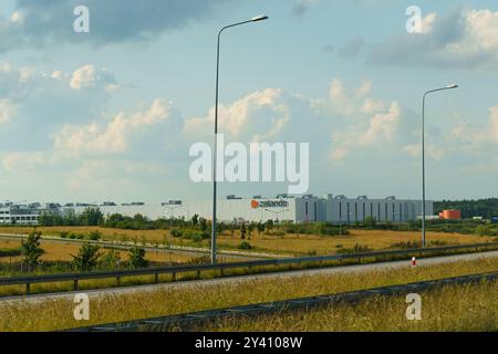 Gliwice, Polonia - 15 giugno 2023: Sullo sfondo si erge un'ampia struttura circondata da campi verdeggianti, con nuvole che si spostano dolcemente verso l'alto. Il Foto Stock