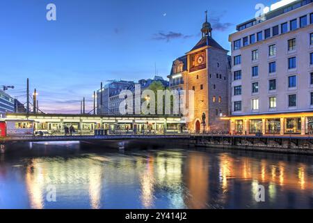 Vista al tramonto del Ponte (Pont) e della Torre (Tour) d'Ile a Ginevra, Svizzera. Questo incrocio di Rhône segna il luogo di nascita della città sin dai tempi dell'epoca romana Foto Stock