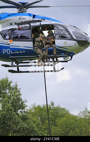 Ein Einsatztrupp des Spezialeinsatzkommandos SEK der Polizei Baden-Württemberg wird mit einem Helikopter der Polizeihubschrauberstaffel BW vom Typ Airbus Helicopters H145 D3 mit der Kennung D-HBWW, zur Darstellung einer Einsatzlage angeflogen. DAS Einsatzteam verlässt den Helikopter mittels eines Seils fast Roping. Hochkant. DAS Spezialeinsatzkommando SEK der Polizei Baden-Württemberg bei einer Vorführung zum Vorgehen bei einer Einsatzlage. Göppingen Baden-Württemberg Deutschland *** Una task force del comando operazioni speciali SEK della polizia di Baden Württemberg viene portata in volo su una S operativa Foto Stock