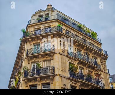 Elegante facciata di un edificio parigino con balconi e attici. Edificio tipico di Parigi, Francia. Foto Stock