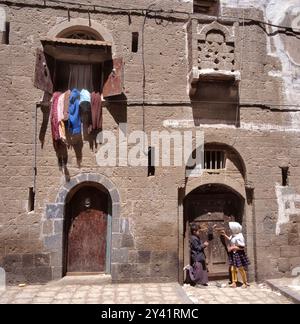 SANAA, YEMEN - 21 APRILE 2011: Due bambini giocano di fronte alla loro casa tradizionale nel centro della città Foto Stock