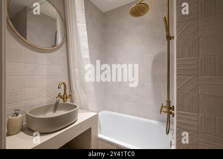 Un bagno elegante e moderno con splendidi arredi in oro, design contemporaneo e comfort Foto Stock