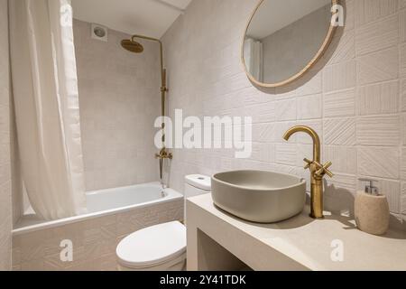 Provate un bagno moderno ed elegante con lussuosi arredi dorati e design minimalista Foto Stock