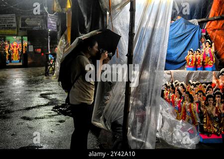 Kolkata, India. 14 settembre 2024. Una fotografa donna scatta foto a Kumartuli, Kolkata. Durga Puja, noto anche come Durgotsava o Sharodotsav, è un festival annuale che si svolge nel subcontinente indiano e che rende omaggio alla dea indù Durga, ed è anche celebrato a causa della vittoria di Durga su Mahishasura. (Foto di Avishek Das/SOPA Images/Sipa USA) credito: SIPA USA/Alamy Live News Foto Stock