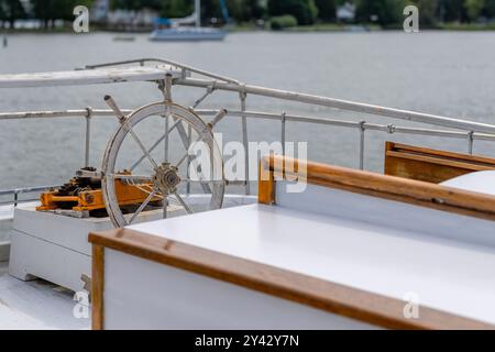 Foto ravvicinata di un timone di una barca a vela, una ruota, mentre era ancorata al porto. Foto Stock