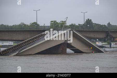 Dresda, Germania. 16 settembre 2024. L'inondazione dell'Elba scorre lungo il ponte Carola parzialmente collassato. Secondo la capitale dello stato sassone, parti del ponte nell'acqua causeranno l'accumulo dell'acqua a monte, causando l'innalzamento del livello dell'acqua su una sezione dell'Elba di circa 30 - 50 centimetri. Crediti: Robert Michael/dpa/Alamy Live News Foto Stock