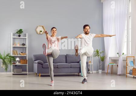 Felice coppia di famiglie che si allenano insieme a casa Foto Stock