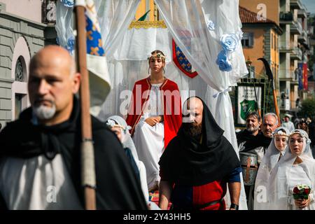 Persone vestite con costumi medievali durante la tradizionale sfilata storica per le strade di Alba, Italia. Foto Stock