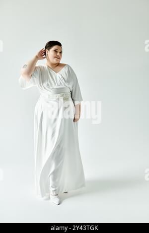 Una splendida sposa Plus size mette in mostra la sua eleganza in un abito da sposa bianco, decorato con orecchini scintillanti. Foto Stock