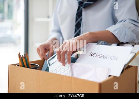 Uomo d'affari che imballa oggetti personali dimissioni o perdita di lavoro Foto Stock