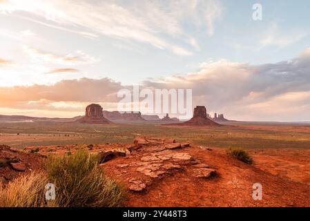 Le arenarie della Monument Valley si illuminano sotto un morbido cielo al tramonto. Foto Stock