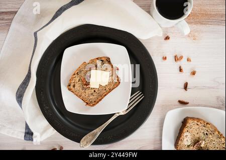 Pane alla banana appena sfornato e caffè su un tavolo da cucina rustico Foto Stock