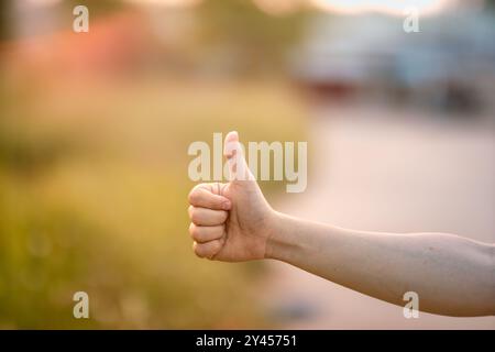 il pollice di un uomo è sollevato verso l'alto. Il gesto della mano mostra come se si stesse lodando qualcosa. Foto Stock