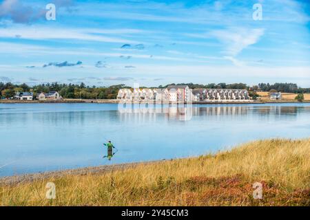 Un pescatore che pesca sull'estuario Ythan alla foce del fiume Ythan vicino a Newburgh Beach, Aberdeenhshire, Scozia Foto Stock