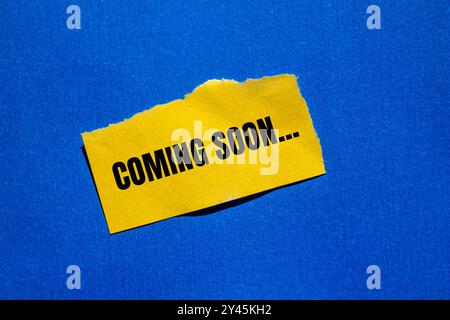 Messaggio in arrivo scritto su un pezzo di carta giallo strappato con sfondo blu. Simbolo concettuale in arrivo. Copia spazio. Foto Stock