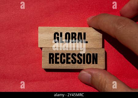 Messaggio di recessione globale scritto su blocchi di legno con sfondo rosso. Simbolo di recessione globale concettuale. Copia spazio. Foto Stock