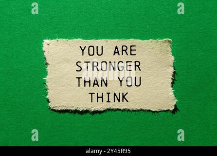 Sei più forte di quanto pensi messaggio scritto su un pezzo di carta strappato su sfondo verde. Concettuale sei più forte di quanto pensi, simbolo. Poliziotto Foto Stock