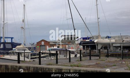 Gosport, Hampshire, Inghilterra. 7 settembre 2024. Alcune delle barche di Gosport Marina e dell'edificio Marine Rigging Services, in una giornata umida. Questa foto fa parte di una serie che ho scattato in una giornata di pioggia durante un recente tour guidato del Royal Clarence Victualing Yard durante i Gosport Heritage Open Days. Foto Stock