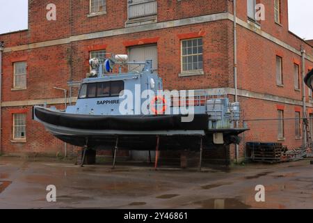 Gosport, Hampshire, Inghilterra. 7 settembre 2024. Primo piano di 'Sapphire', una motovedetta montata su un terreno asciutto accanto ad un edificio in mattoni. Questa foto fa parte di una serie che ho scattato in una giornata di pioggia durante un recente tour guidato del Royal Clarence Victualing Yard durante i Gosport Heritage Open Days. Foto Stock