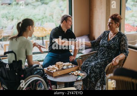 Ragazzo con la sindrome di Down e gli amici giocano mattoncini insieme Foto Stock