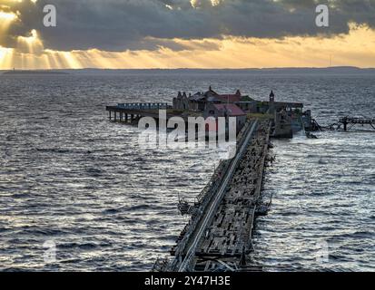 Il vecchio molo di Birnbeck a Weston Super Mare, Somerset, Regno Unito, è estremamente fatiscente e pericoloso, ma dovrebbe essere restaurato presto, con i raggi del sole Foto Stock