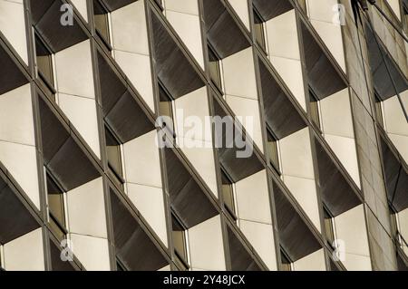 Facciata architettonica moderna con ripetuti motivi geometrici alla luce del sole urbano Foto Stock