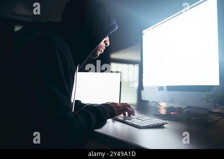 Hacker, uomo e cyber crimine con schermo vuoto e computer per hacking e codifica di sicurezza. Online, criminali e frodi con violazione dei dati, malware e. Foto Stock
