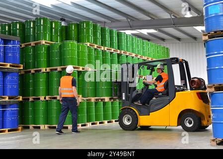 Gruppo di lavoratori nell'industria logistica lavorare in un magazzino con prodotti chimici - Sollevamento del carrello Foto Stock