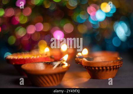 Primo piano di Diwali Diya o lampada su sfondo bokeh colorato. Messa a fuoco selettiva Foto Stock