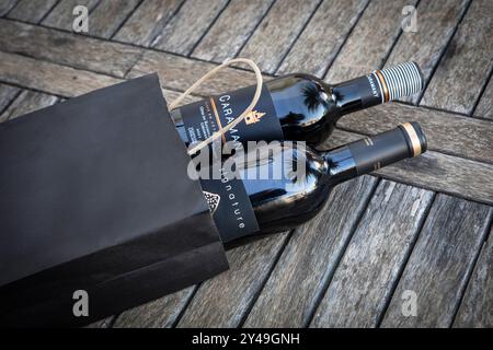 Due bottiglie di vino rosso francese in un sacchetto di carta nero. Foto Stock