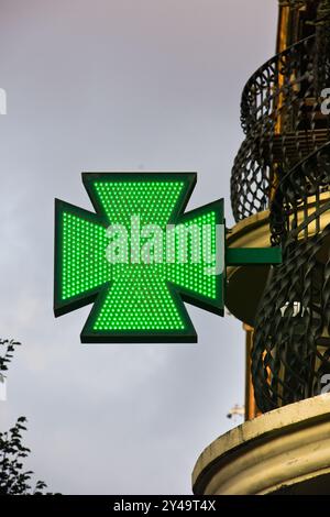 Segnaletica verde illuminata per farmacia con luci a LED. Barcellona, Catalogna, Spagna. Foto Stock