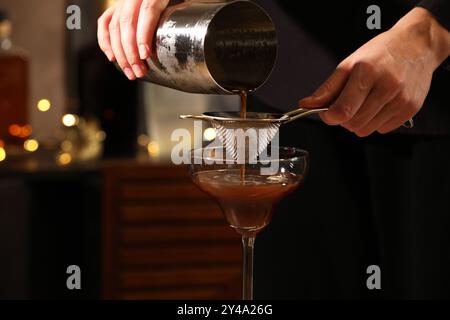 Barman che prepara deliziosi martini espresso al bar, primo piano Foto Stock