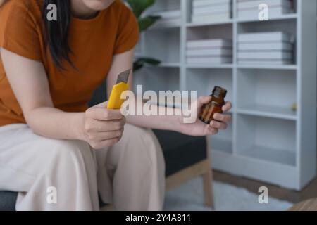 La donna, seduta sul divano di casa, fissava il cutter e la bottiglia della medicina, sopraffatta dalla depressione, colta in una dolorosa battaglia interna Foto Stock