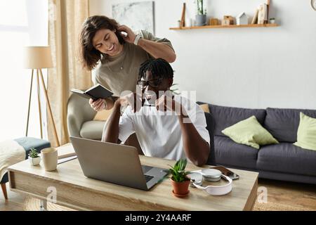Un momento di gioia si apre mentre una coppia condivide risate e calore mentre lavora a casa. Foto Stock
