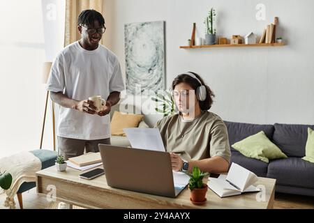 Una coppia felice condivide un momento tenero mentre si destreggia tra lavoro e caffè a casa. Foto Stock