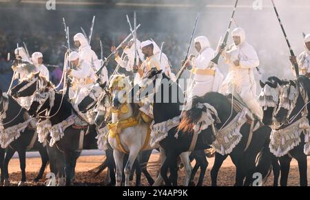 Nel cuore del Marocco, Fantasia brilla per i suoi colori vivaci e il suo potente display. Maestosi cavalli e cavalieri valorosi, avvolti da abiti vivaci, Foto Stock