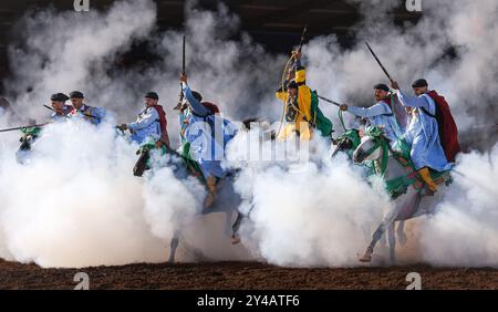 Nel cuore del Marocco, Fantasia brilla per i suoi colori vivaci e il suo potente display. Maestosi cavalli e cavalieri valorosi, avvolti da abiti vivaci, Foto Stock