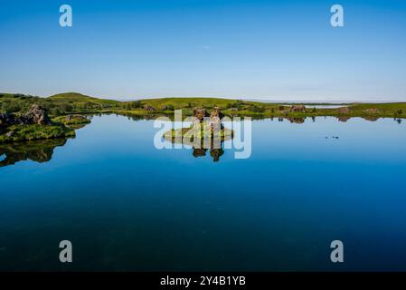 Lago vulcanico Myvatn con riflessi e isole, prati verdi e cieli blu nell'Islanda settentrionale lago vulcanico Myvatn con riflessi e isole, Foto Stock