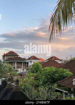 Splendido cielo all'alba su tetti di tegole rosse di case a Ubud, Bali Foto Stock