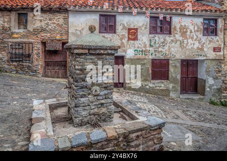 Esplora le pittoresche strade di Yanguas a Soria, con antiche case in pietra e una pittoresca fontana circondata dalla storia. Foto Stock